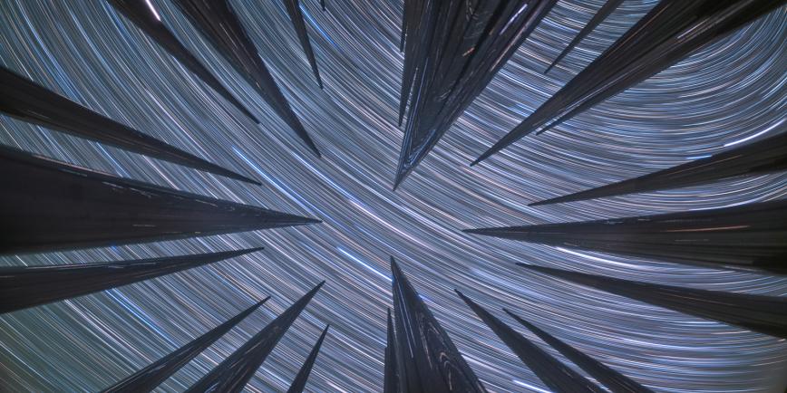 Star trails stretching above metal columns