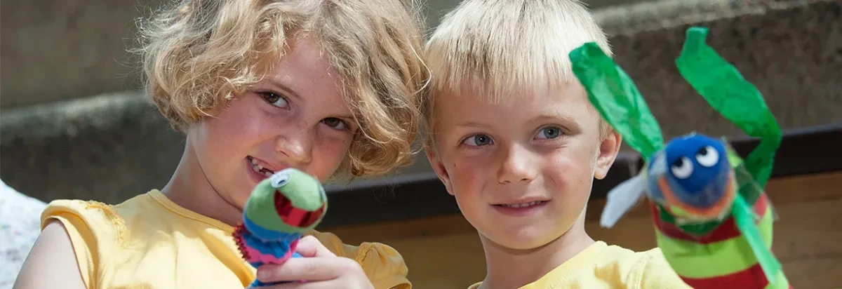 Two children playing with sea monster toys.