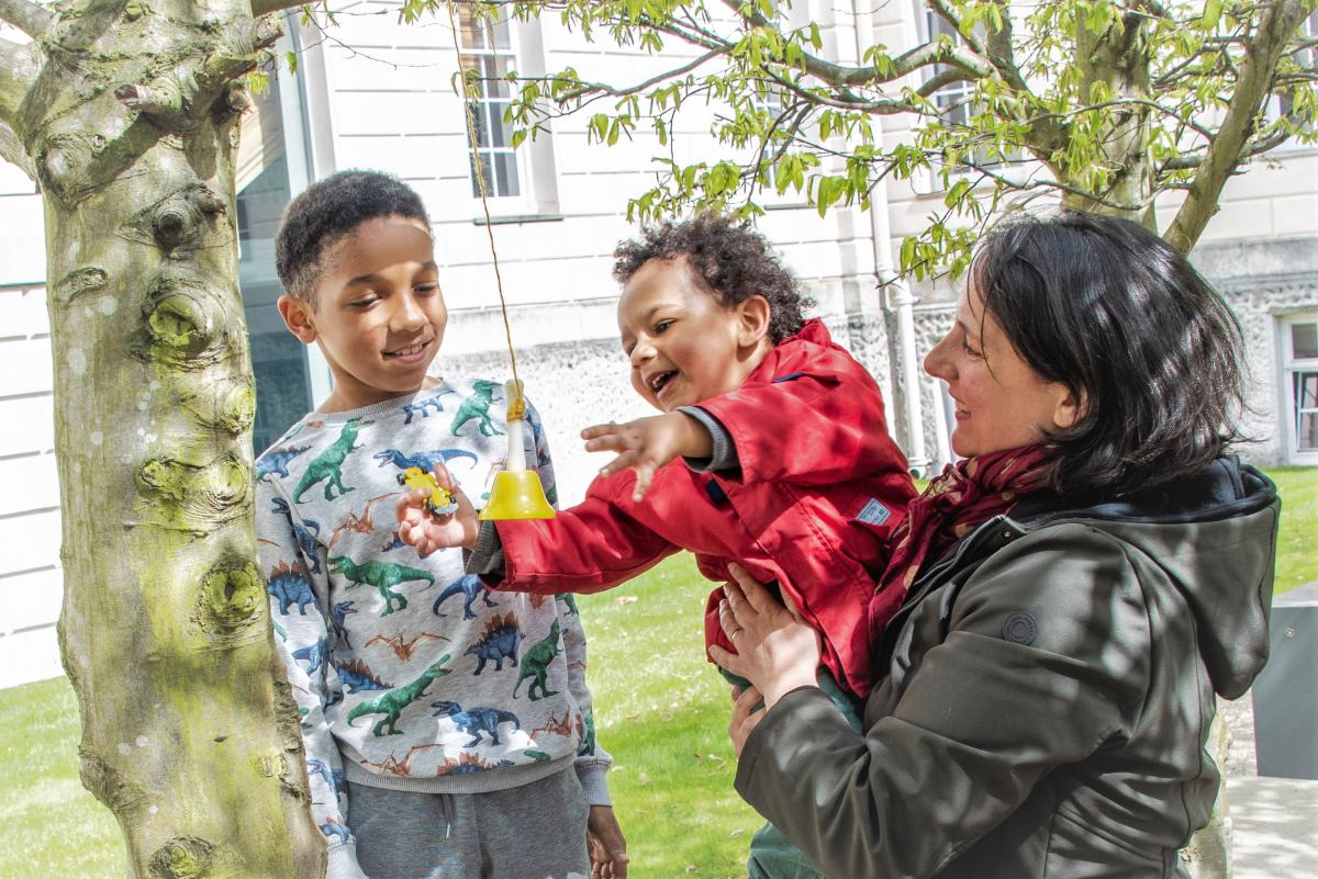 A family plays in the grounds of the National Maritime Museum