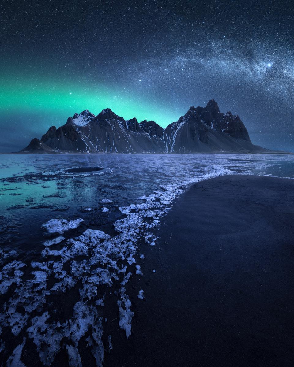 Milky Way and aurora over mountains in Iceland