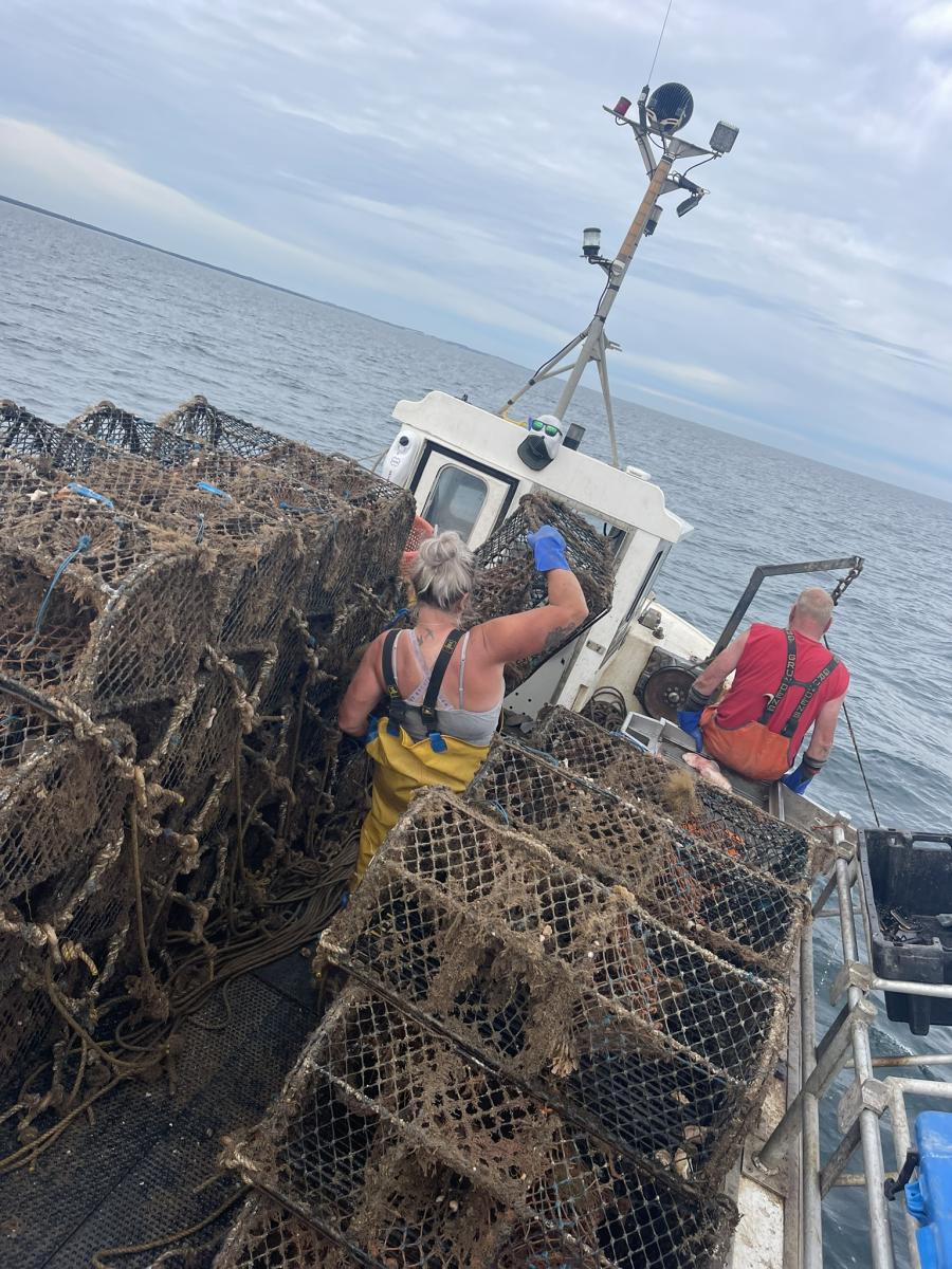 Ashley Mullenger on fishing boat stacking crates