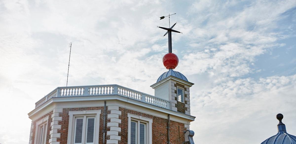 Image of old historical building of Flamsteed House at the Royal Observatory with big red ball on sliding pole with weathevane at top