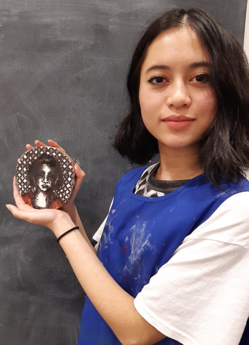 A member of Saturday Art Club holds up their artwork