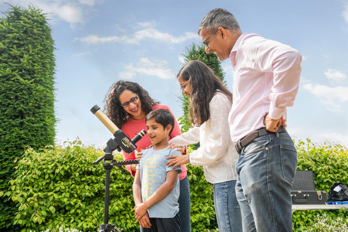 A family enjoy looking through a telescope during a science demonstration at the Royal Observatory