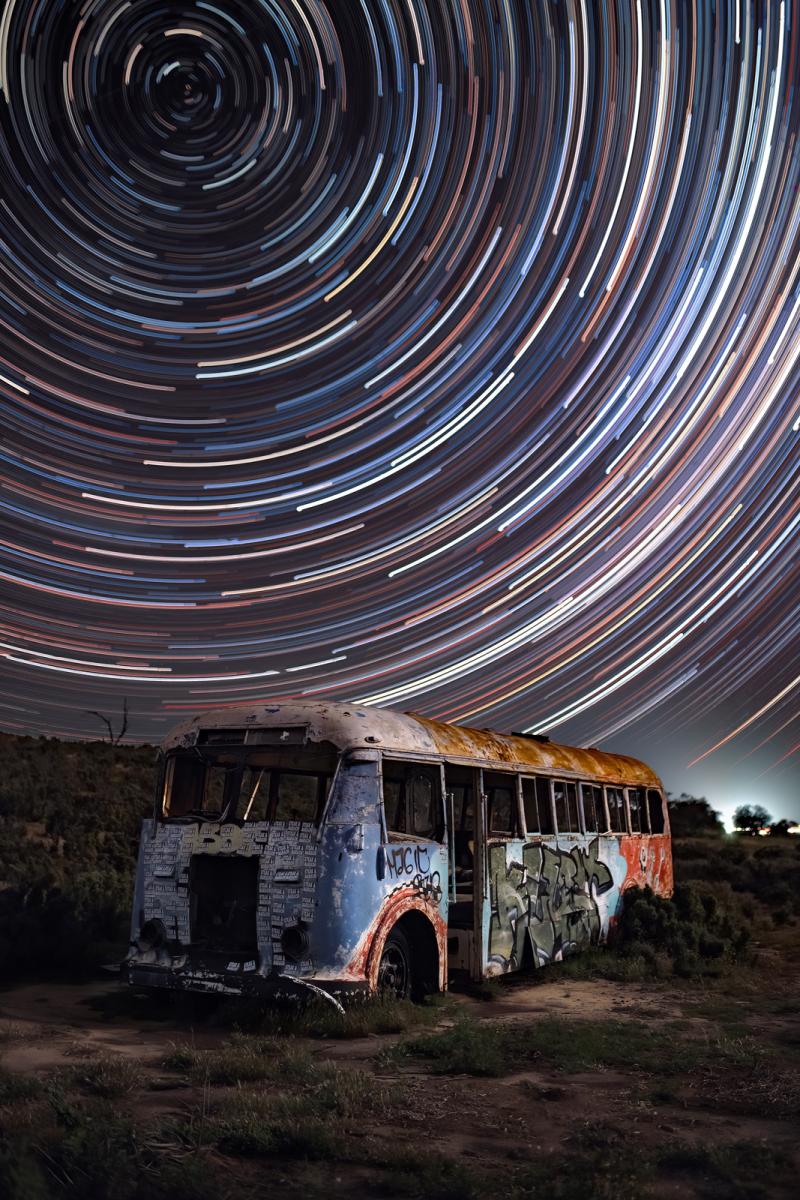 Abandoned bus with circular star trails above