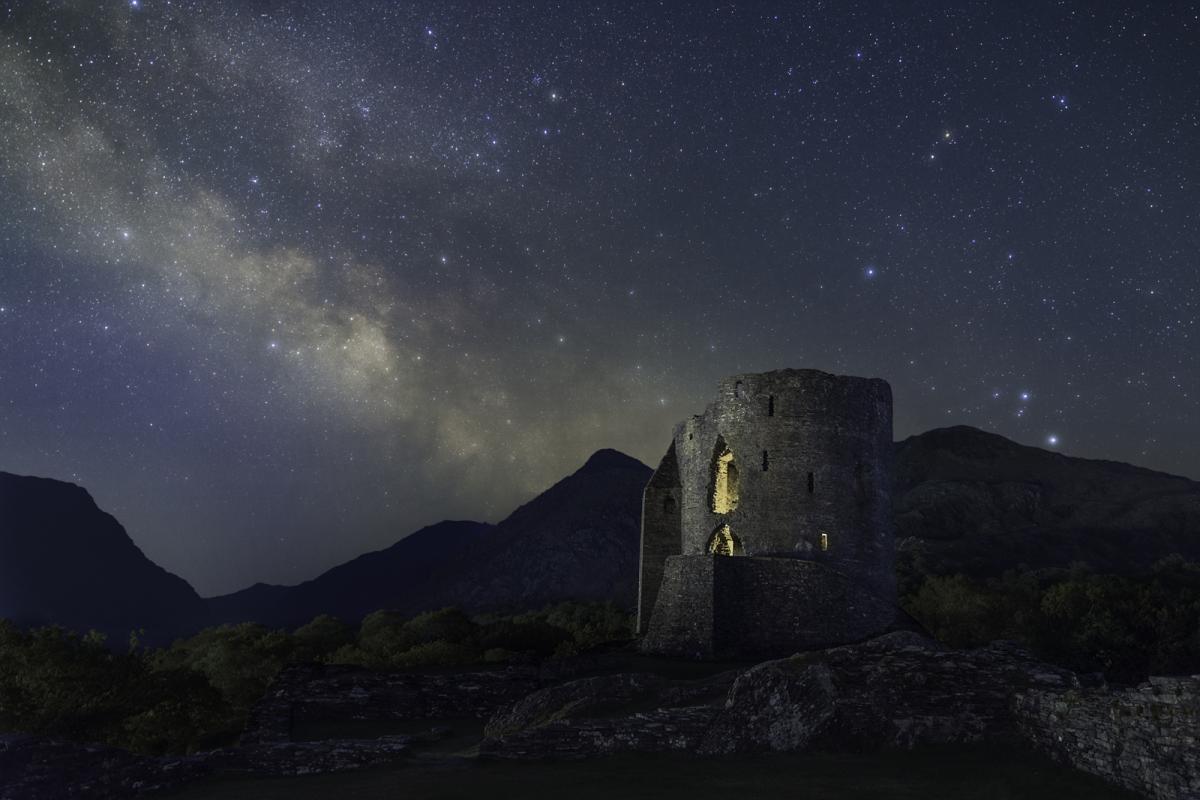 Milky Way rising behind a castle turret in the mountains