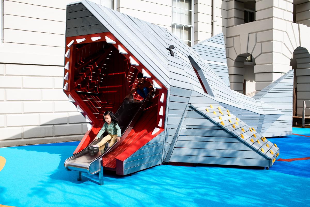 Kids play on 'Cutty Shark', a giant shark-shaped slide and climbing apparatus in the National Maritime Museum's outdoor playground