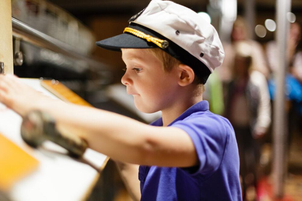 Child with hat on a boat