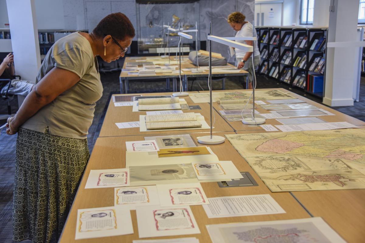 A woman looks at a display of documents in the library of the National Maritime Museum