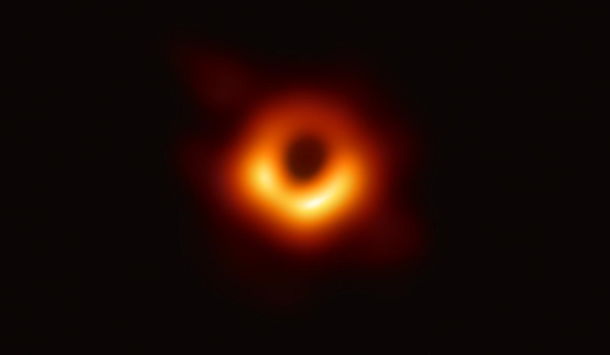 The first image of a black hole, seen as a glowing orange ring in the centre of an almost completely black frame