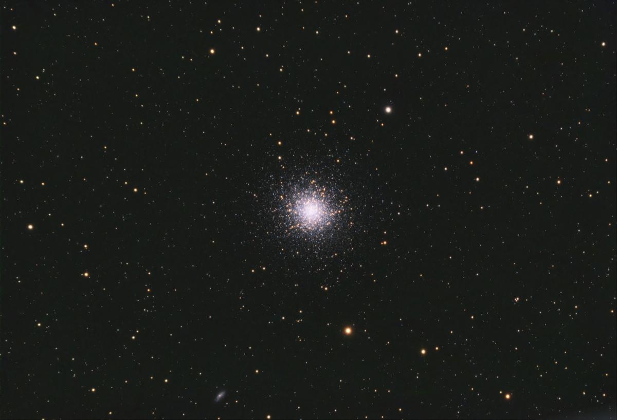 Image of bright cluster of hundreds of stars in the distance amongst a black starry sky