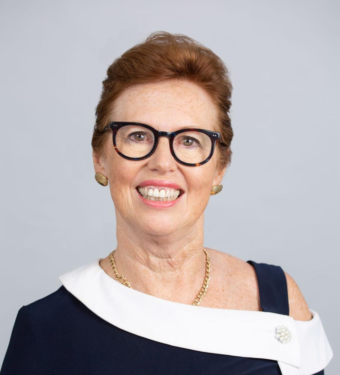 Headshot of Toner Stevenson; a woman with short hair and glasses wearing a black and white top