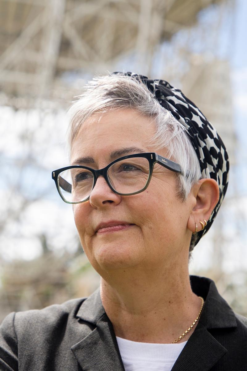 Portrait photograph of Teresa Anderson. She is wearing dark glasses, a smart blazer and a blue and white patterned headscarf