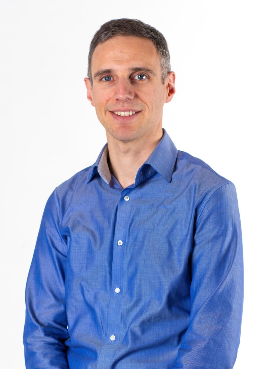 Royal Museums Greenwich 2025 Boardroom Apprentice Robert Kairis. He is wearing a blue shirt with a collar, looking relaxed and smiling at the camera