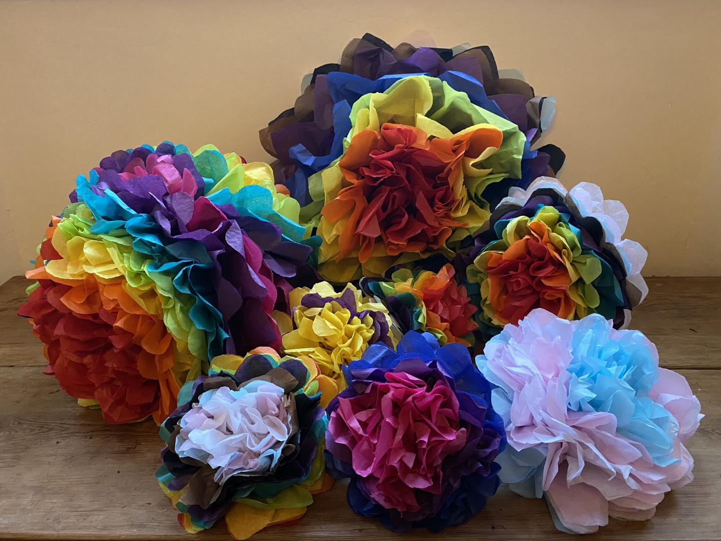 Collection of multicoloured pom poms in different sizes