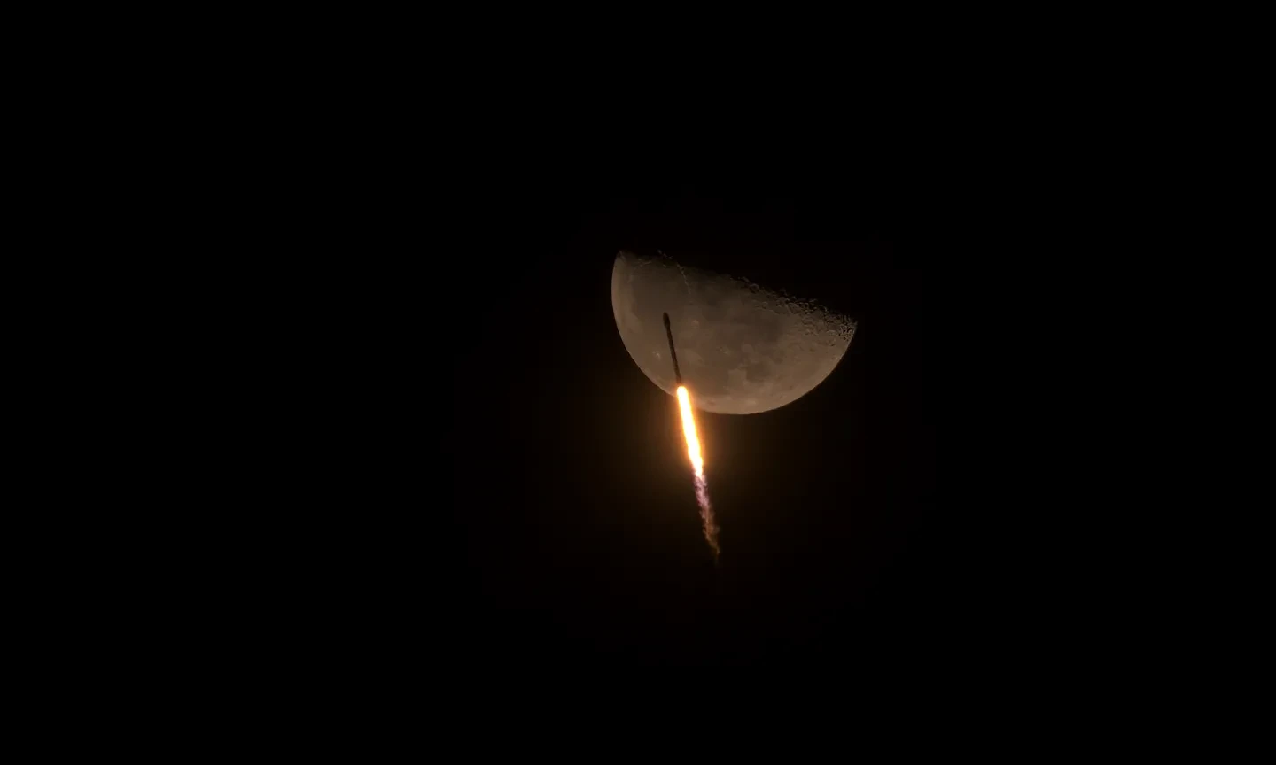 An astronomy photograph showing Falcon 9 soaring past the moon