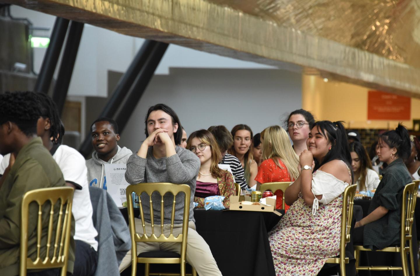 A group of young people watching performers as part of Spill the Tea