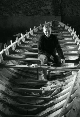 woman sitting inside the ribs of a boat