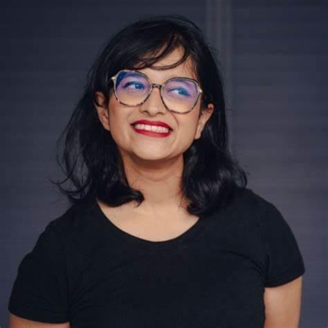 Photo headshot of a woman with glasses smiling