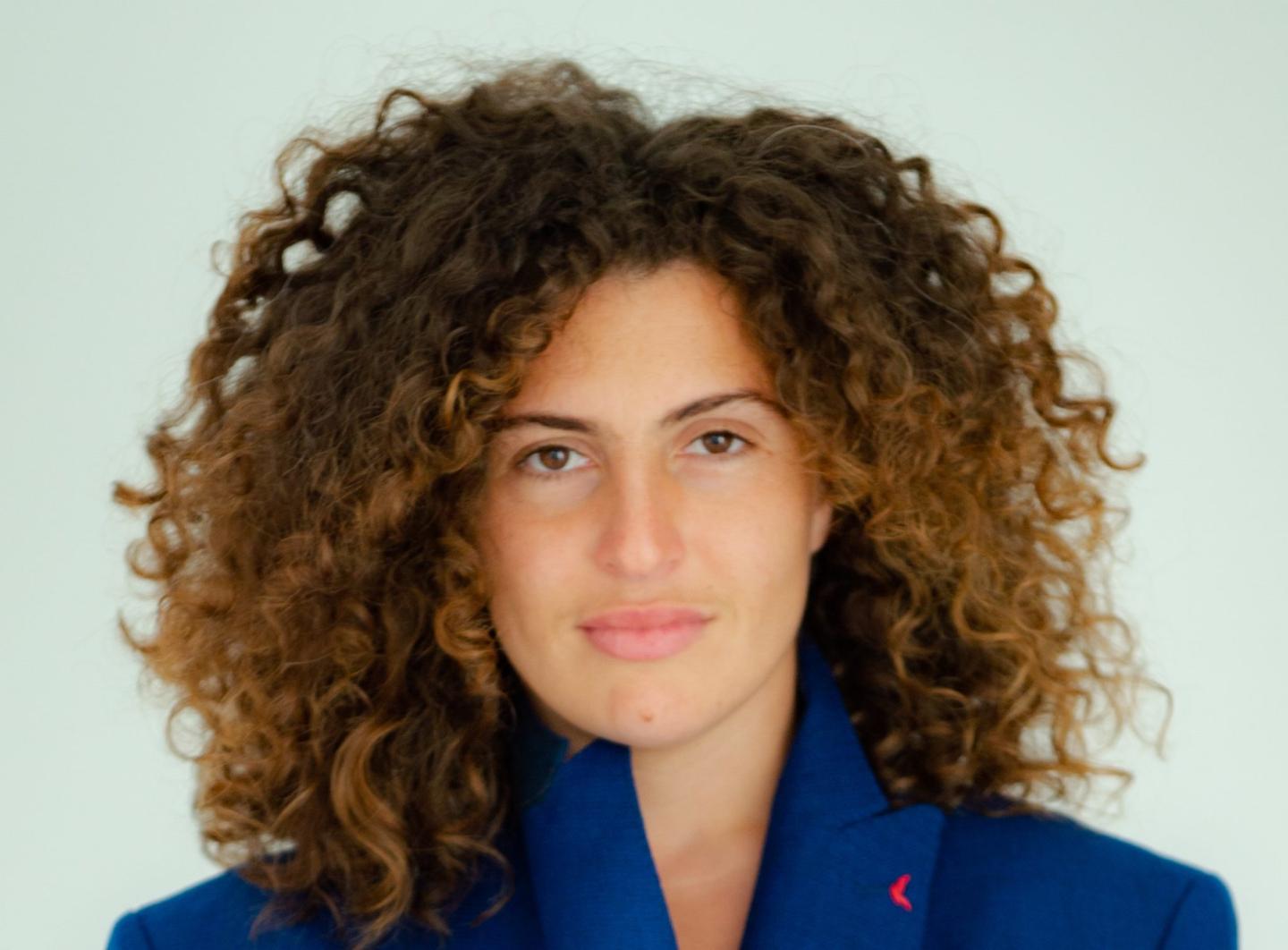 headshot of a woman with brown curly hair