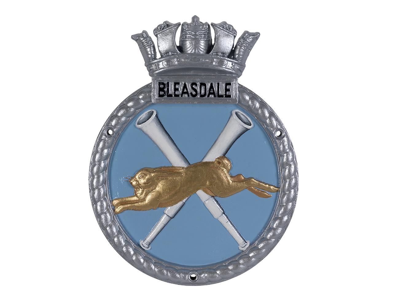 a ship's badge with a golden hare and 2 telescopes in the background