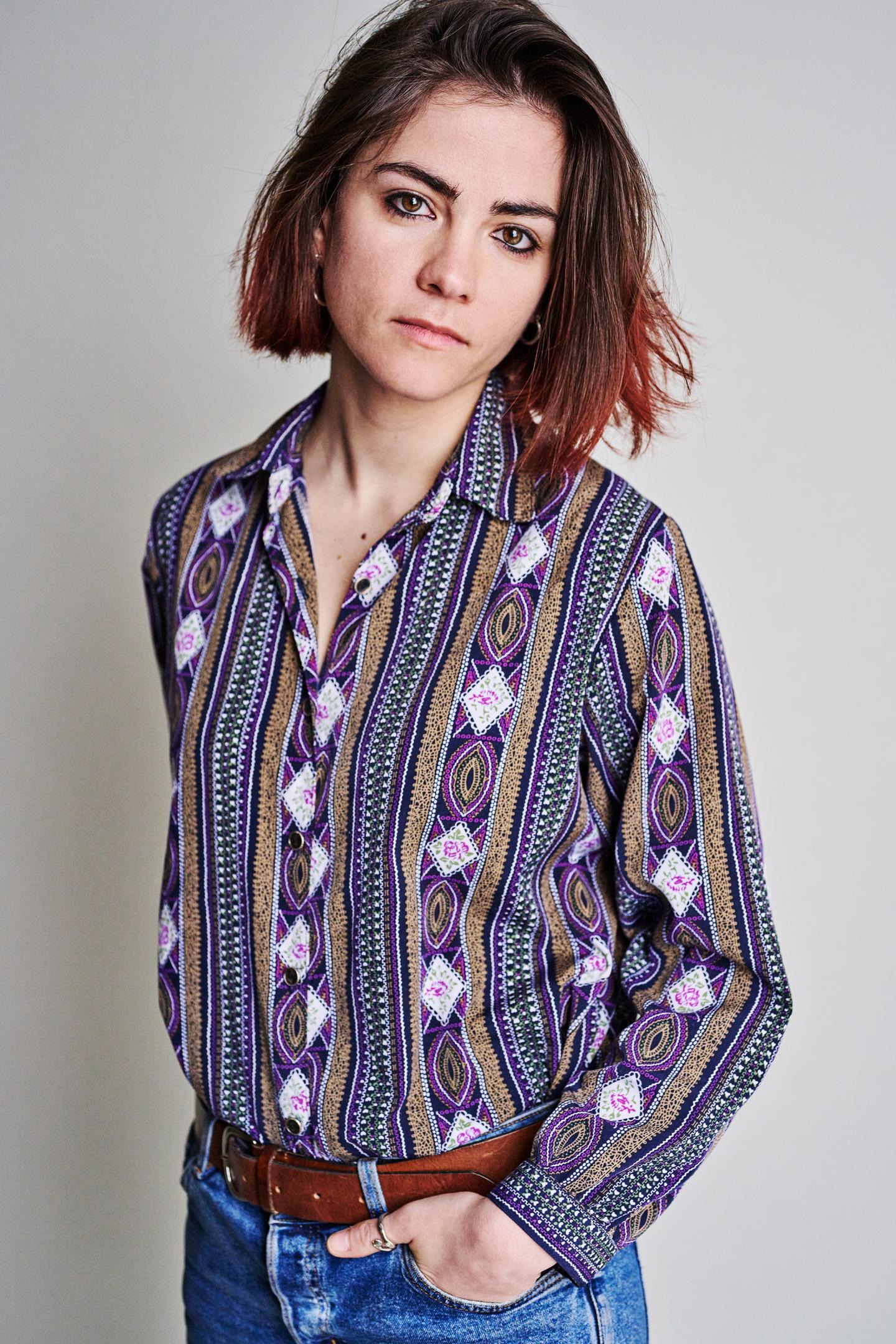 young woman standing with her hand in her jeans