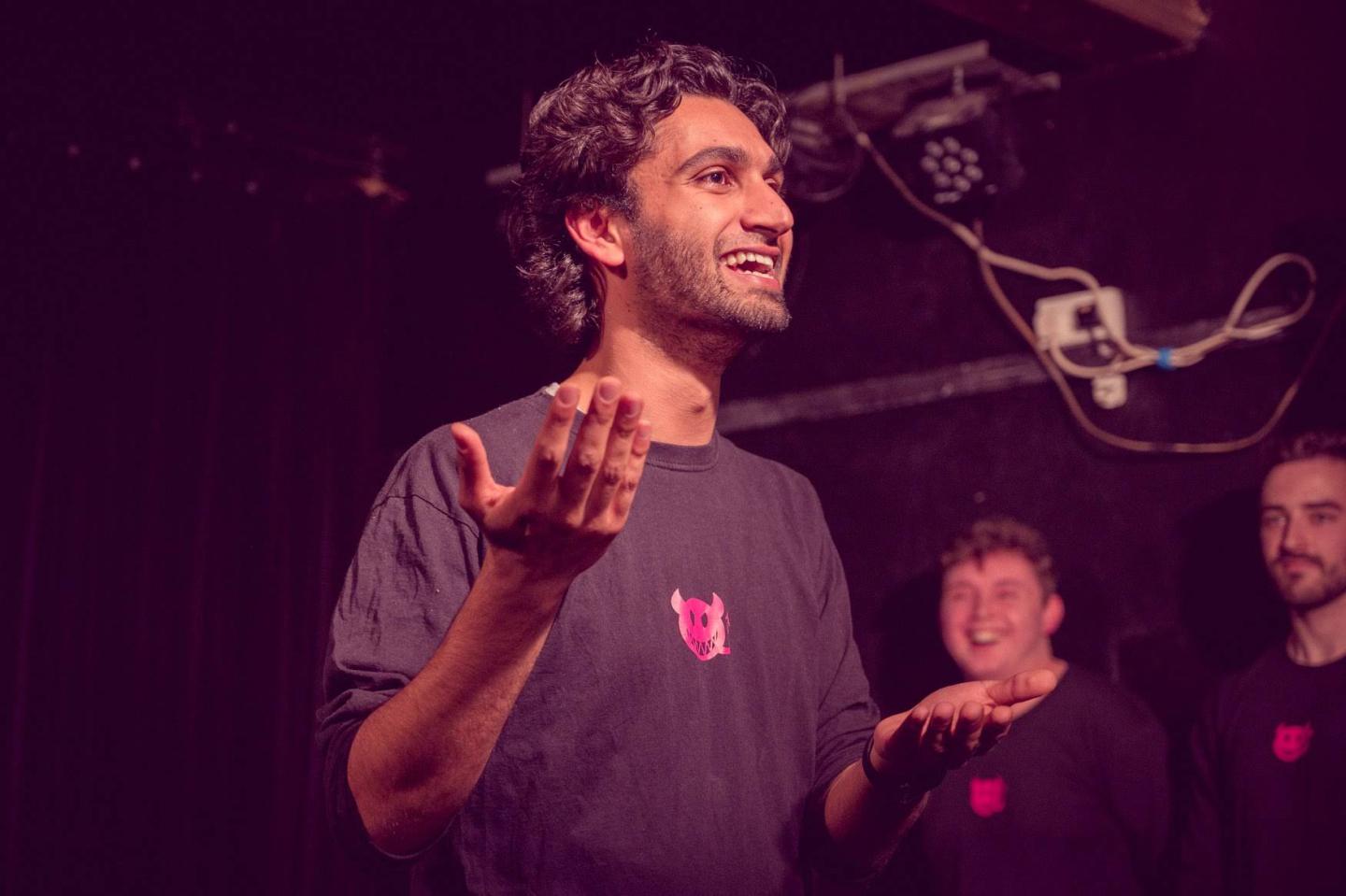 man performing to an audience with hands in the air 