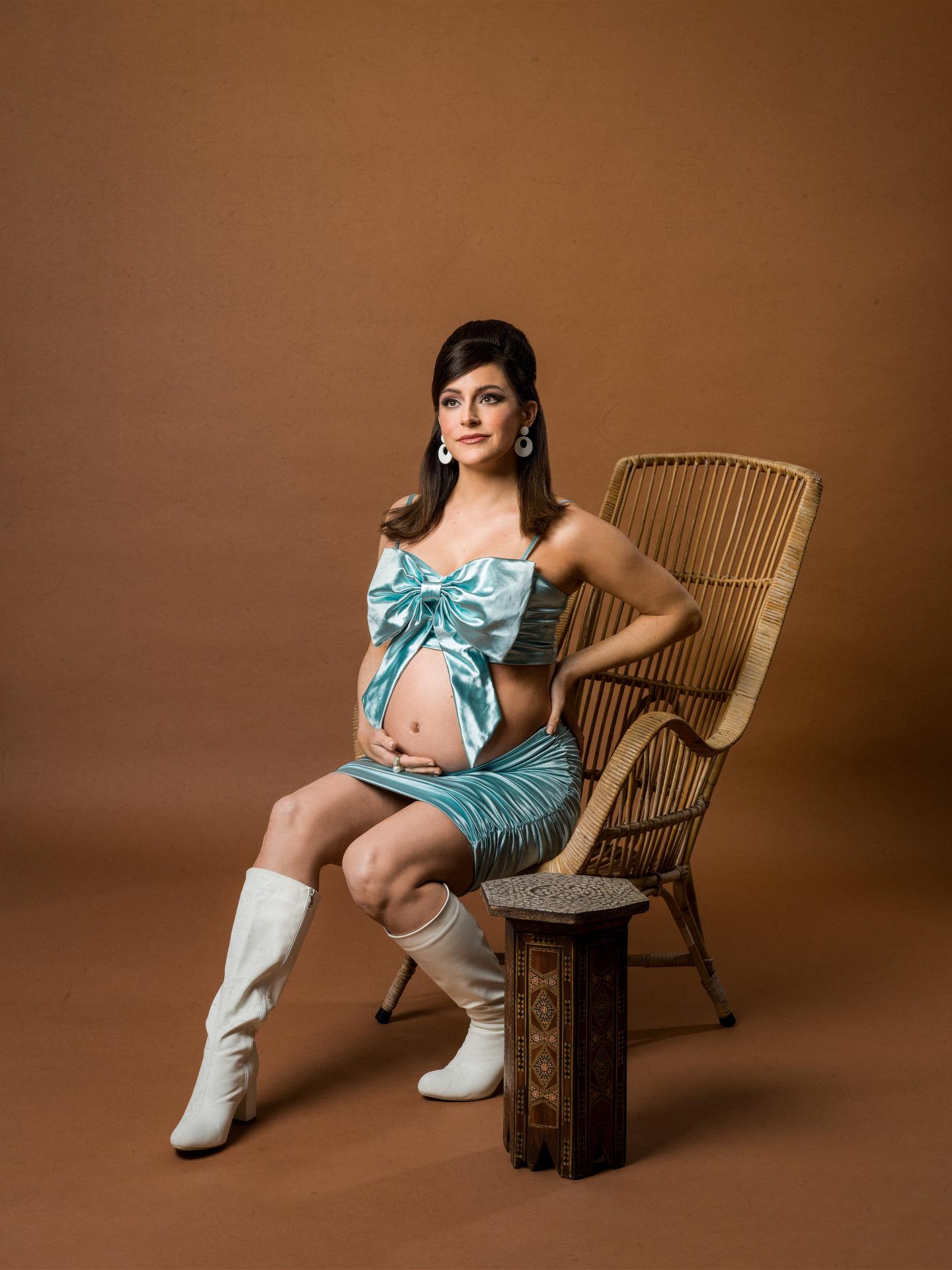 Image of Janine Harouni sitting down in front of a brown background