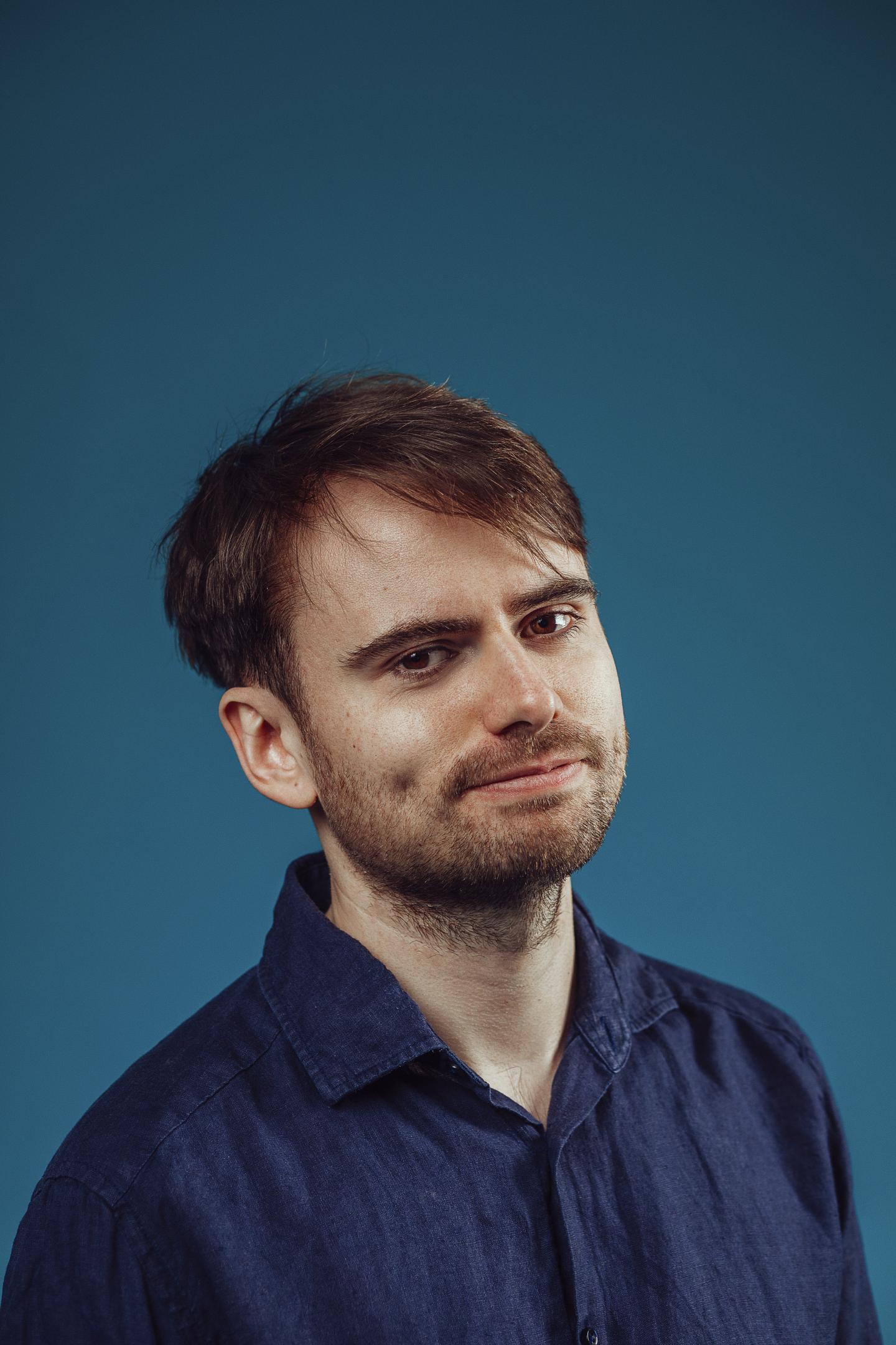 Image of Will Gillespie Rowland in front of a blue background