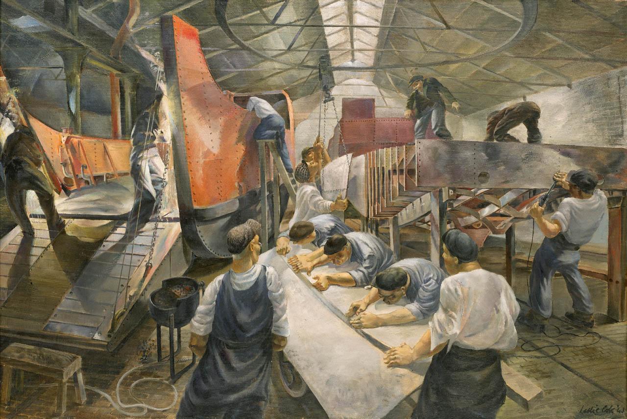 Industrial scene of work men building landing craft in a warehouse for the war effort.