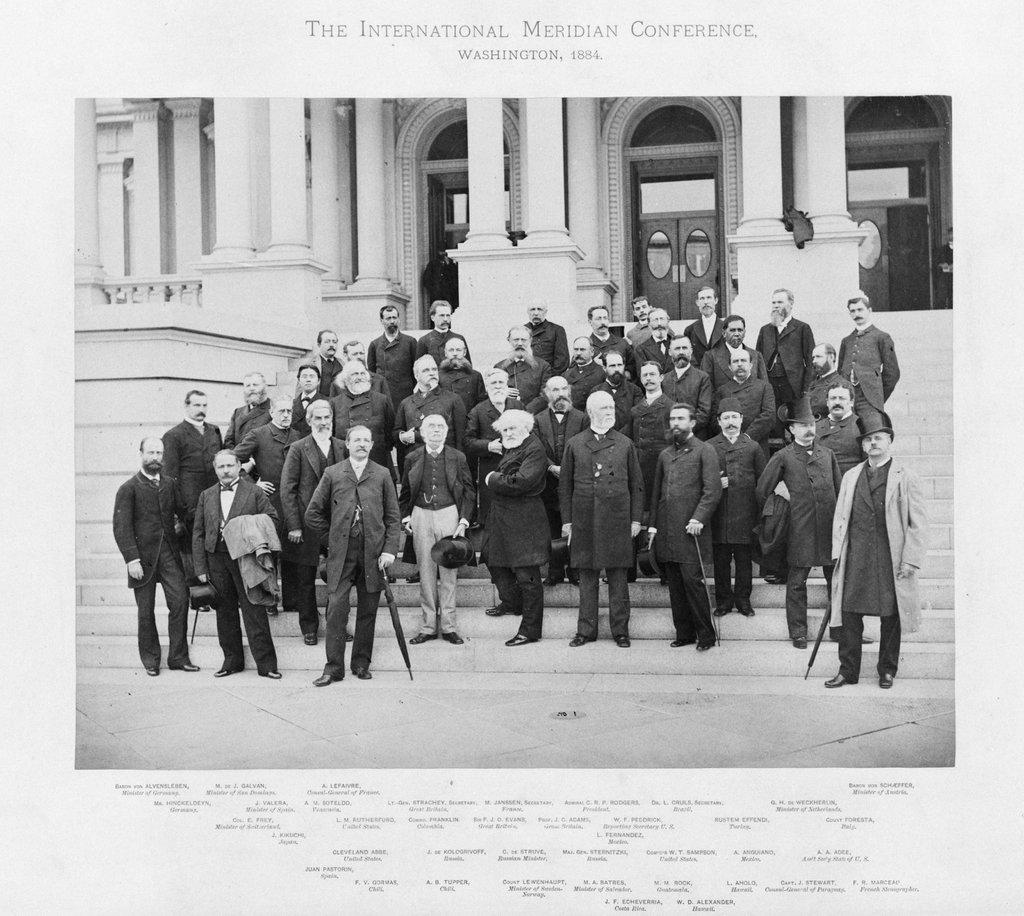 Historic black and white photograph of a group of scientists and delegates standing on the steps outside a grand building