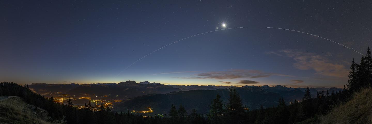 Image of alpine landscape with International Space Station, Venue and the Moon in the sky