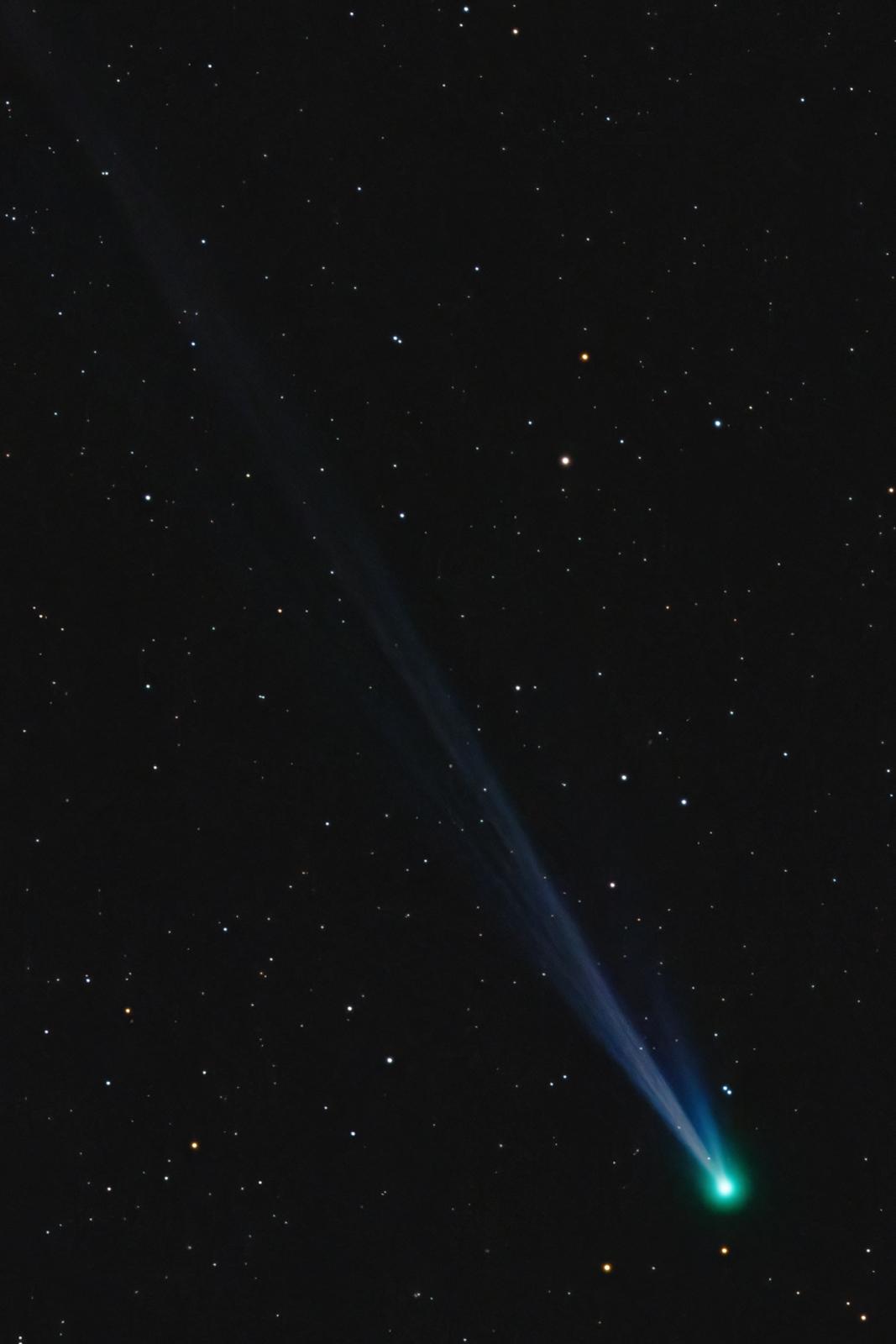 Telescope view of a comet - the comet itself is visible in the bottom right corner, with its tail streaming diagonally across the camera view