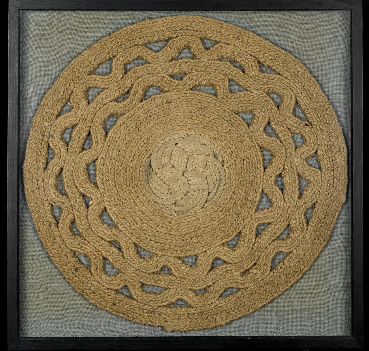 Image of a round placemat made out of thin bits of rope in a design