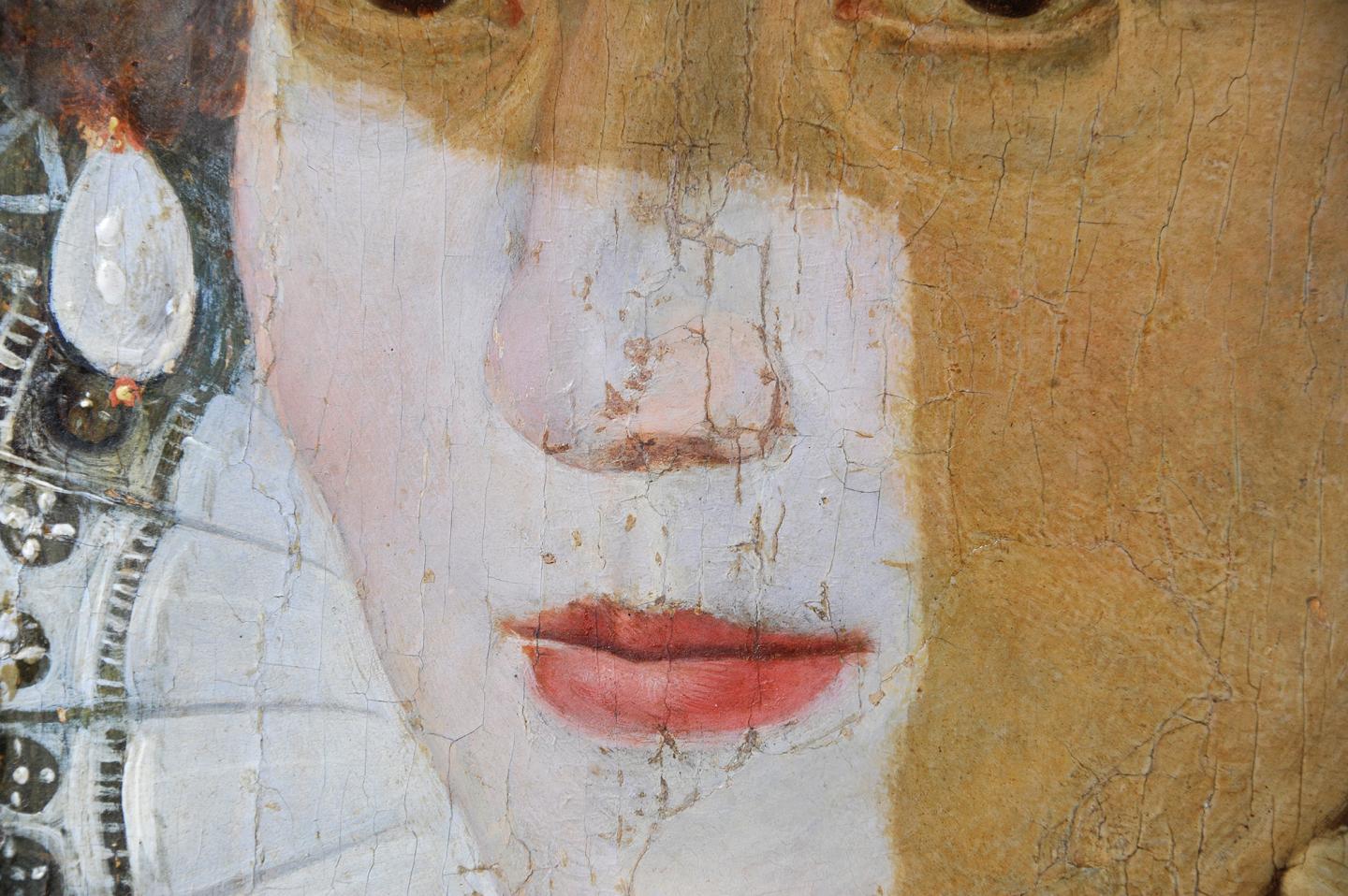 Close-up of the Armada Portrait of Elizabeth I during the painting's conservation. Part of the face shows an area where the yellow varnish has been removed