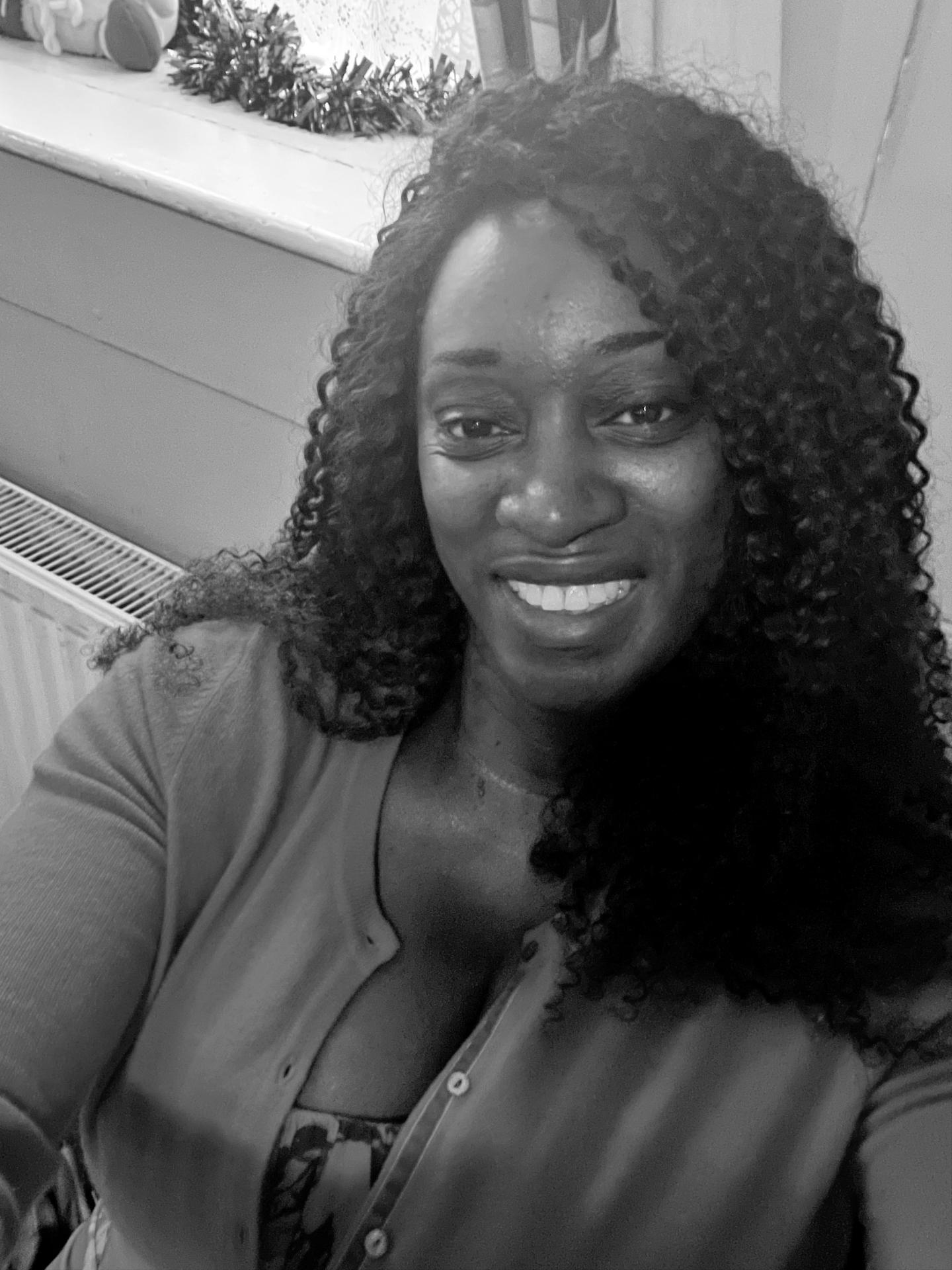 B&W head shot of a black woman who has long spiraled hair