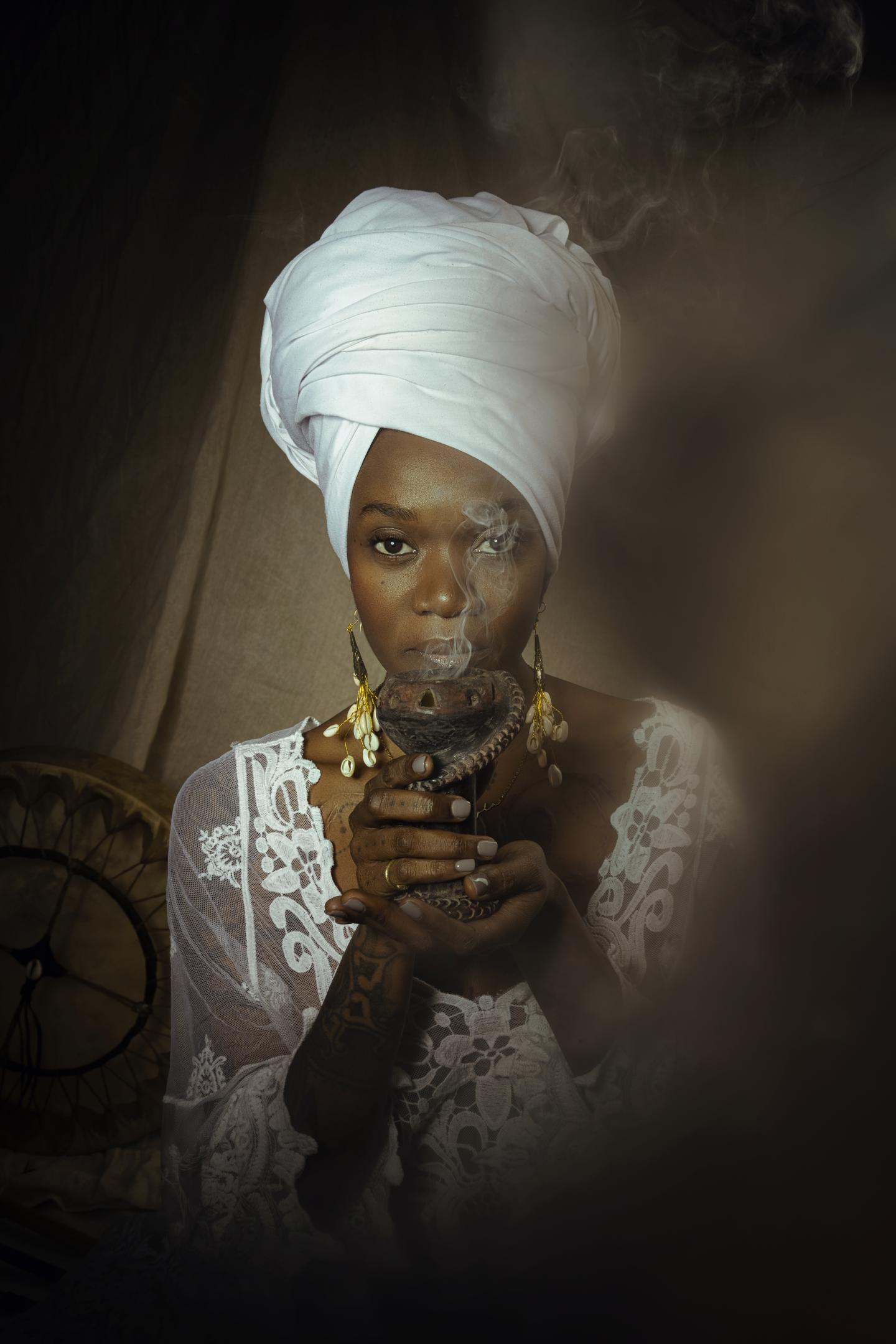 photo of a black woman with a white turban holding a pot 