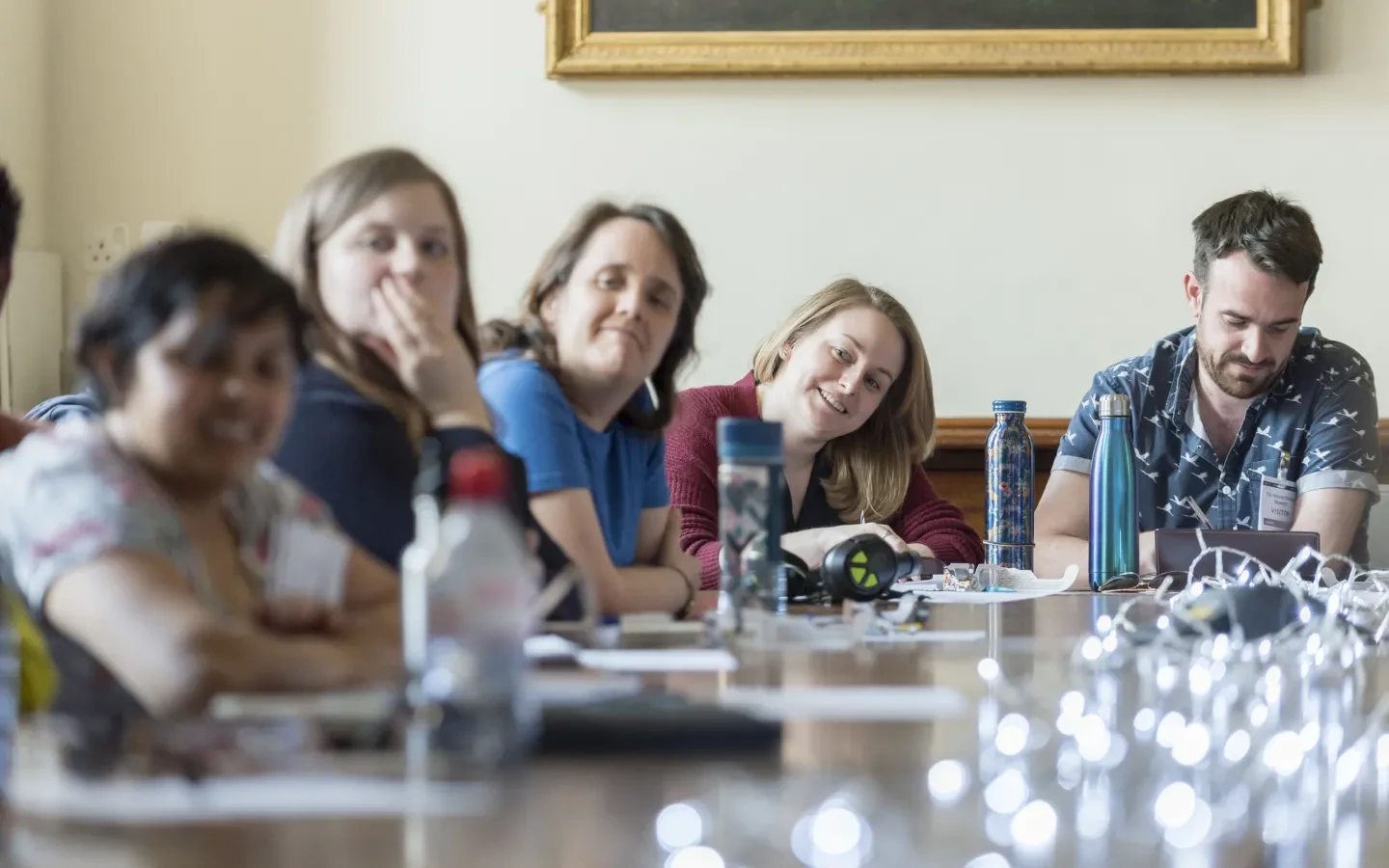 A group of people at a table looking attentively at something off camera.