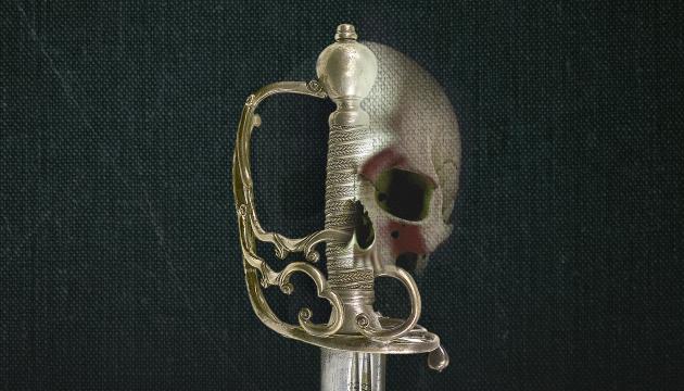 The gold hilt of a sword against a dark fabric background. The outline of a human skull has been digitally superimposed on to the right side of the hilt, creating an unsettling central motif 